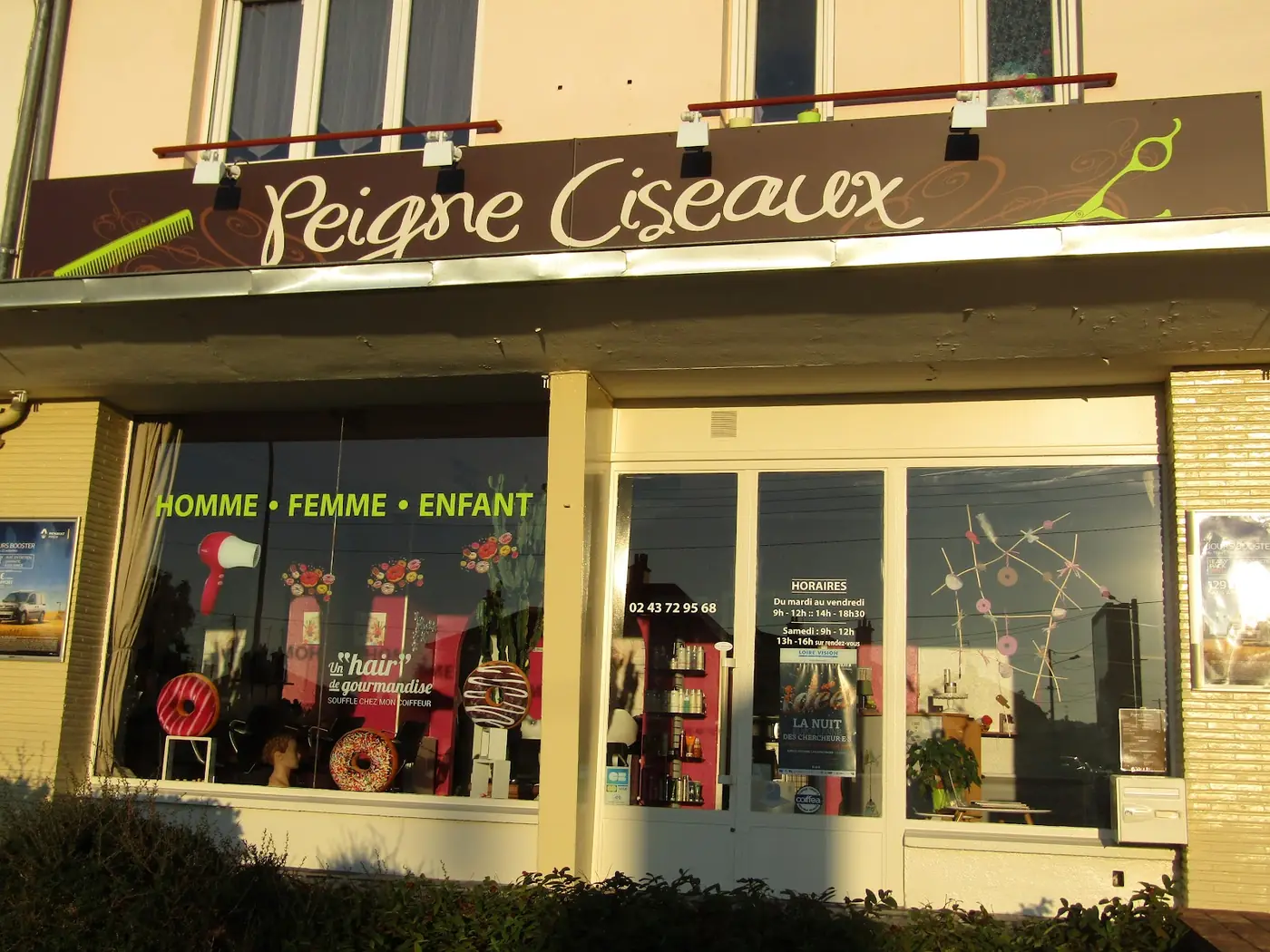 La devanture de Peigne Ciseaux : l'enseigne marron et la vitrine Homme, Femme, Enfant